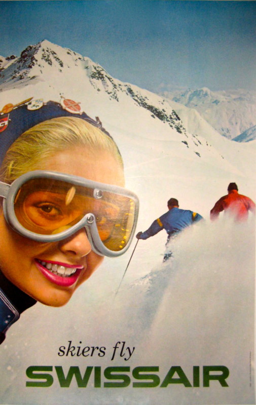 Woman wearing ski goggles with the backs of skiers on a mountain in background