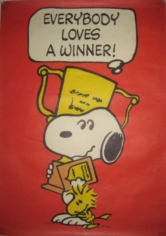 Snoopy the dog holding trophies with Woodstock the bird hugging him