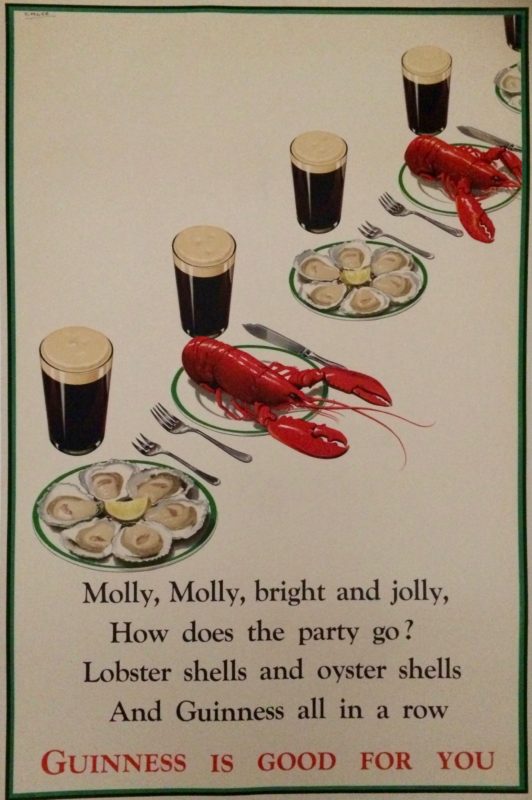 lobsters, oysters, and pints of beer set at a table