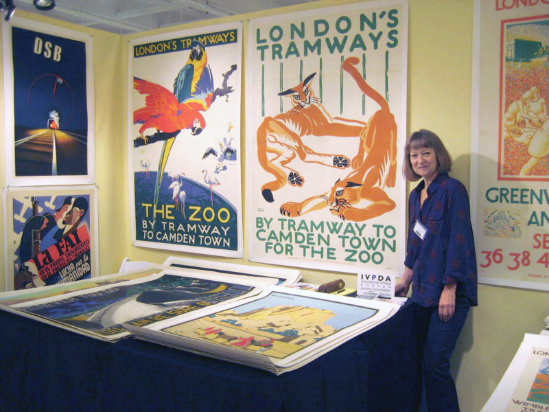 Woman at a table showing posters at the Poster Fair NYC 2015